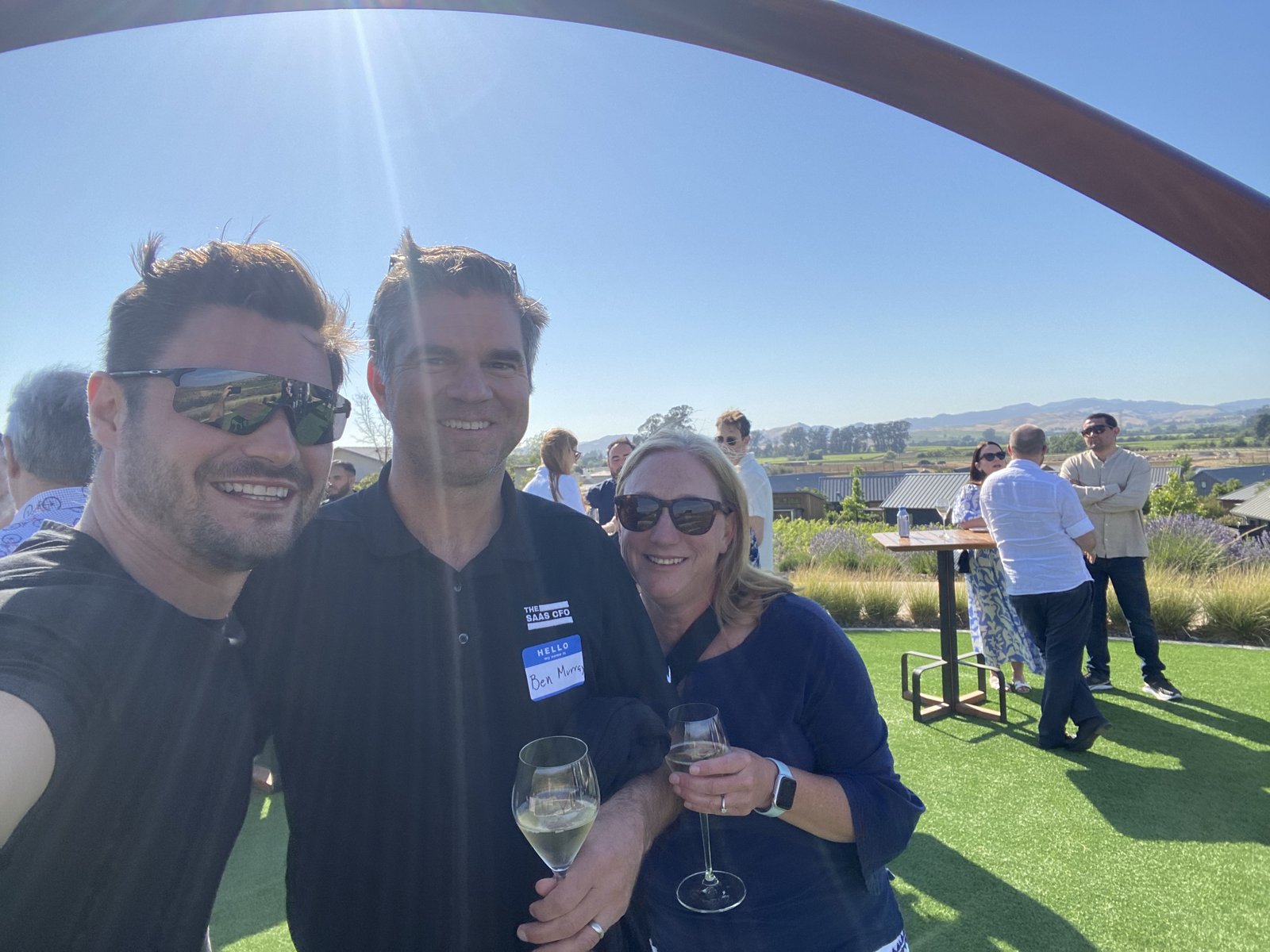 Founders toasting with wine beneath the steel arch