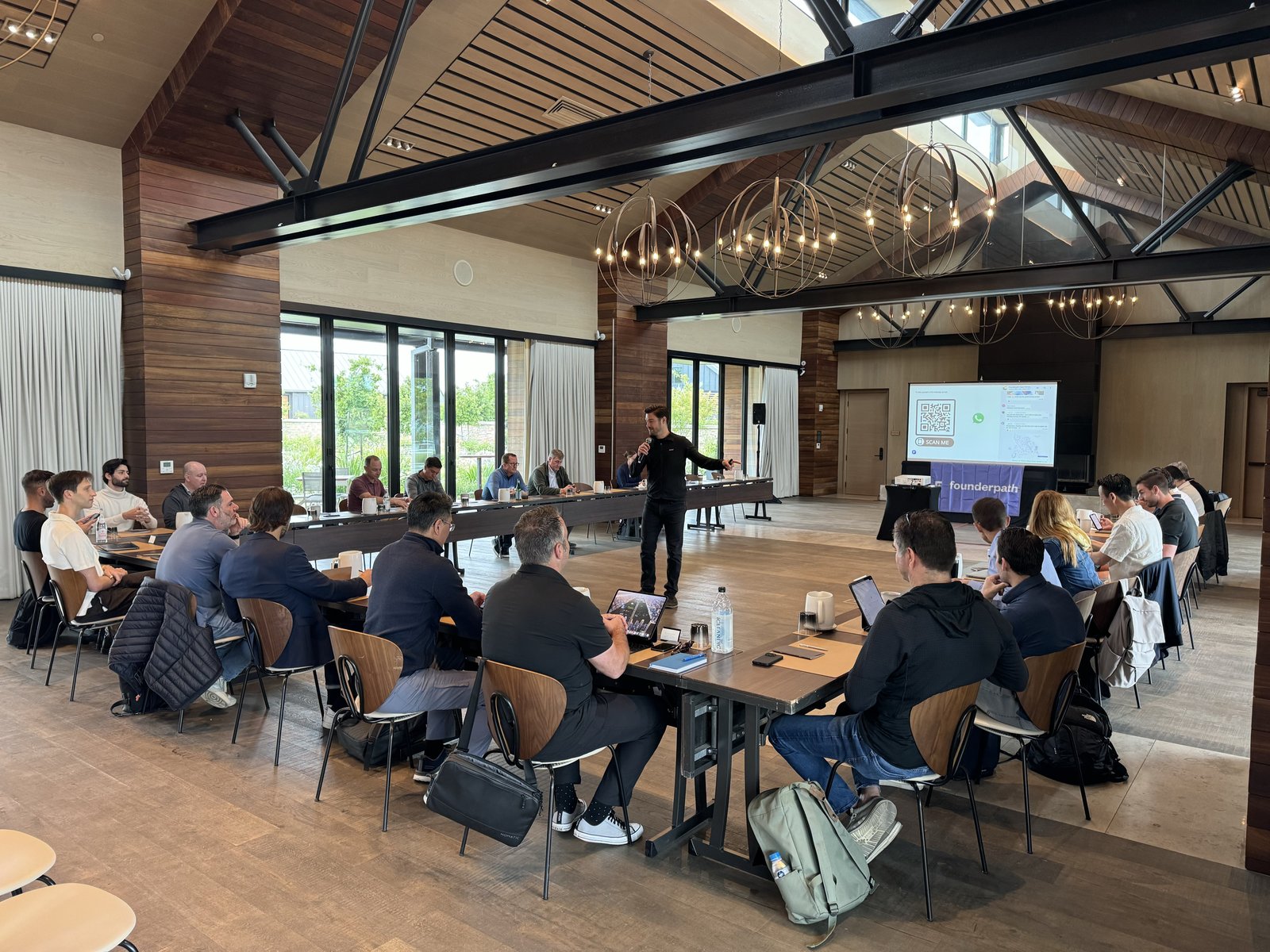 A speaker leading a keynote session for founders seated around the table